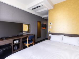 静冈Hotel Wing International Shizuoka的配有一张床和一台平面电视的酒店客房