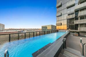 墨尔本Sol Docklands - Unique 3 Bedroom Loft, Infinity Pool, Gym, Free Parking and Free Trams的建筑物屋顶上的游泳池