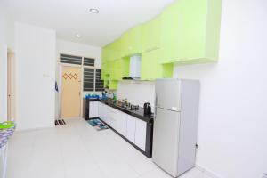 马六甲Alleysya's Homestay的厨房配有绿色和白色的橱柜和冰箱。