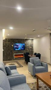 Salmahبيوت الخزام的带沙发的客厅和砖墙上的电视