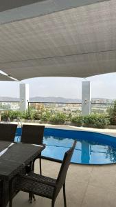 Salmahبيوت الخزام的一个带桌椅的庭院和一个游泳池