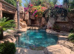 肯普顿帕克老鹰岩行政旅馆的一座带岩石墙和鲜花的小游泳池