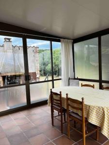 圣塔克里斯蒂纳阿鲁Can Catrol的一间带桌椅和大窗户的用餐室