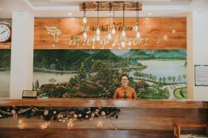 宁平Thung Nham Resort的站在一个大壁画前面的人