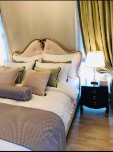 伊斯坦布尔luxury apartments in Istanbul的一张带枕头的床和一张桌子上的台灯