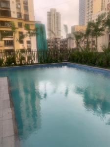 孟买Room in Flat with Amazing City and Sea View的一座拥有建筑的城市里的大型蓝色游泳池