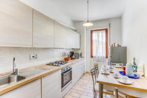 马里纳迪马萨Casa Arno 500m from beach的厨房配有白色橱柜和桌椅