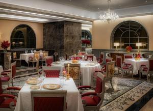 澳门Palazzo Versace Macau的餐厅配有白色的桌椅和吊灯