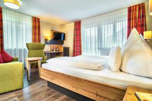 拉姆贝尔瓦尔德酒店的酒店客房带一张大床和一把椅子