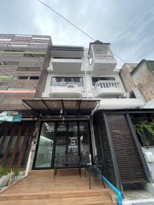 清迈Comfort Zone Hostel @ Tha Pae的玻璃门和甲板上的长凳的建筑