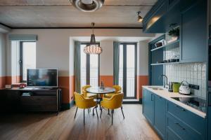 阿姆斯特丹The July - Boat & Co的厨房配有蓝色橱柜和一张带黄色椅子的桌子