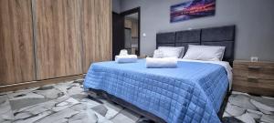 哈尔基斯Mimarxos Luxury Apartments的一间卧室配有蓝色的床和2条毛巾