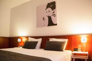 Asperen德思卡普酒店的一间卧室设有两张床,墙上挂着一幅画