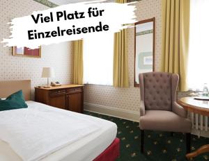魏玛Boutique-Hotel Amalienhof的酒店客房配有一张床、一张桌子和一把椅子。