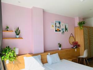 吉婆岛Rustic house的卧室配有白色的床和粉红色的墙壁