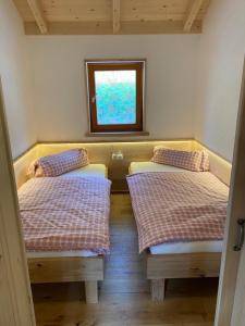 皮恩山口附近施皮塔尔Ferienhütte Sonnreith的小型客房 - 带2张床和窗户