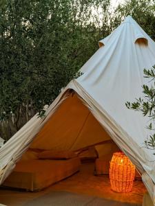 卡萨米尔Garden Lake Camping的白色和橙色的帐篷,配有一张床