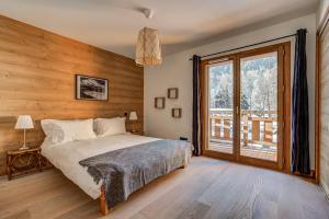 夏蒙尼-勃朗峰Residence Le Green的一间卧室设有一张床和一个大窗户
