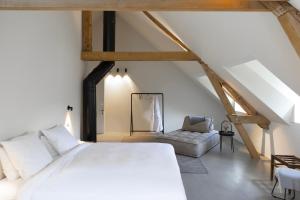 Habay-la-NeuveChâteau du Pont d'Oye的卧室配有白色的床和椅子