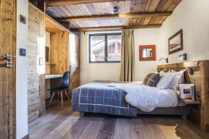 夏蒙尼-勃朗峰Chalet Black Wood的一间卧室配有一张床、一张书桌和一个窗户。