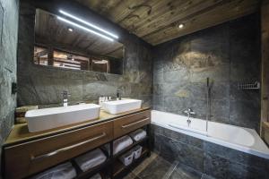 夏蒙尼-勃朗峰Chalet Black Wood的浴室设有2个水槽、浴缸和镜子