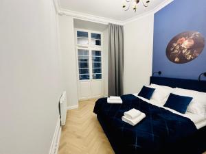弗罗茨瓦夫HO!HOUSE Bulwar Staromiejski的蓝色和白色的卧室设有床和窗户