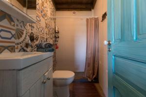 阿加尼尔Casa da Avó Emília的一间带卫生间、水槽和蓝色门的浴室