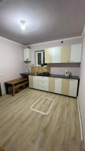 塞凡Sevan Hotel的一间铺有木地板的大厨房,配有白色的橱柜