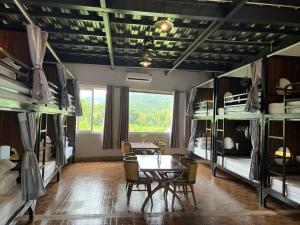 河江Rocks Ha Giang Hostel & Tour的客房设有桌椅和双层床。