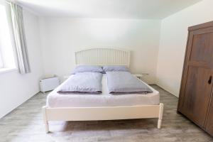 ŘikoviceChalupa Říkovice的卧室配有白色的床和枕头。