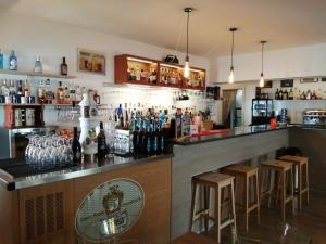 特雷维尼亚诺罗马诺Malì Trevignano Piccolo Hotel的酒吧,备有几瓶酒和凳子