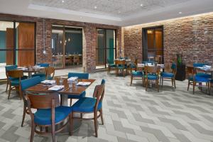 华盛顿华盛顿市中心/会议中心万豪原住客栈的餐厅设有木桌和蓝色椅子