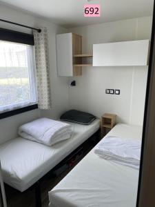 莱马特davorel mobil home的小型客房 - 带2张床和窗户