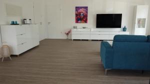 不来梅港Ferienhaus Urlaubshafen的客厅配有蓝色的沙发和电视
