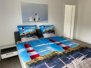 不来梅港Ferienhaus Urlaubshafen的一间卧室配有一张带红色和白色灯塔床罩的床。
