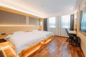 北京得瑞酒店(北京顺义国展店)的一间卧室配有两张床、一张桌子和一台电视。