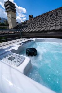 蓬泰迪莱尼奥Le Suites de San Campel RTA的热水浴缸和遥控器