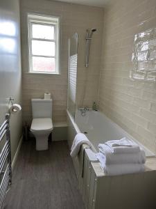 史云顿戈达德阿姆斯酒店的带浴缸、卫生间和盥洗盆的浴室