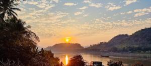 琅勃拉邦Villa Phonethip Mekong Riverside的享有河流和日落美景