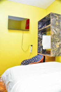 MeruFour seventy的黄色客房,配有床和镜子