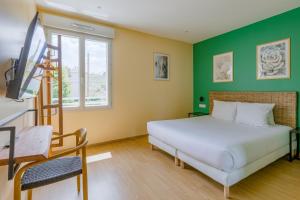 拉图迪潘Hôtel de la Tour的卧室配有白色的床和绿色的墙壁