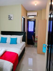 安汶Maluku Residence Syariah的一间卧室配有一张床、一张桌子和一把椅子