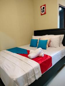 安汶Maluku Residence Syariah的卧室内的两张床,配有色彩缤纷的床单和枕头