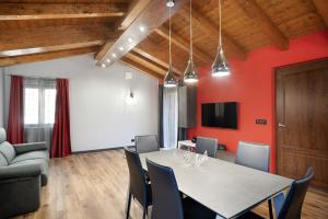 维拉诺瓦达尔本加Agriturismo il Borgo - Rosmarino的一间拥有红色墙壁和桌椅的用餐室