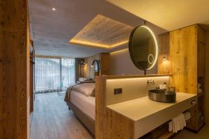 采尔马特Hotel Bellerive的一间卧室配有床、水槽和镜子