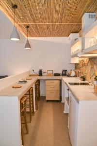 特里皮蒂Mylopetra Milos Suites的厨房配有白色的柜台和木制天花板