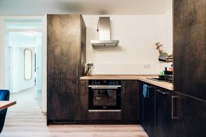 巴登-巴登MELLoWY: Edles Apartment mit Platz für 8 Personen的厨房配有深色木质橱柜和烤箱。