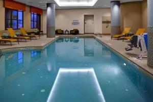 迪凯特亚特兰大迪凯特市中心/埃默里万怡酒店的酒店客房的大型游泳池配有椅子