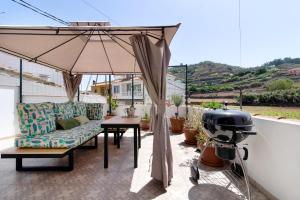 特罗尔Las Monarcas的庭院配有遮阳伞和桌椅。