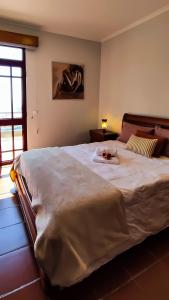 丰沙尔Casa Gina, with views to Funchal Bay的卧室配有一张白色大床,上面有女士